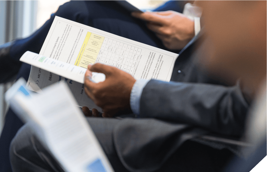 Closeup of several hands, each holding open industry report for the Constructing Building Integrity: Raising Standards Through Professionalism ARC Linkage Project